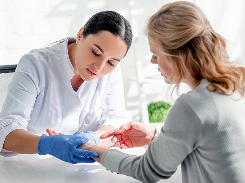 Dermatologista analisando o braço de paciente