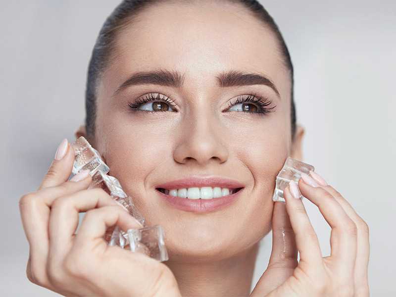 Imagem de uma mulher passando gelo no rosto para melhorar a qualidade da pele