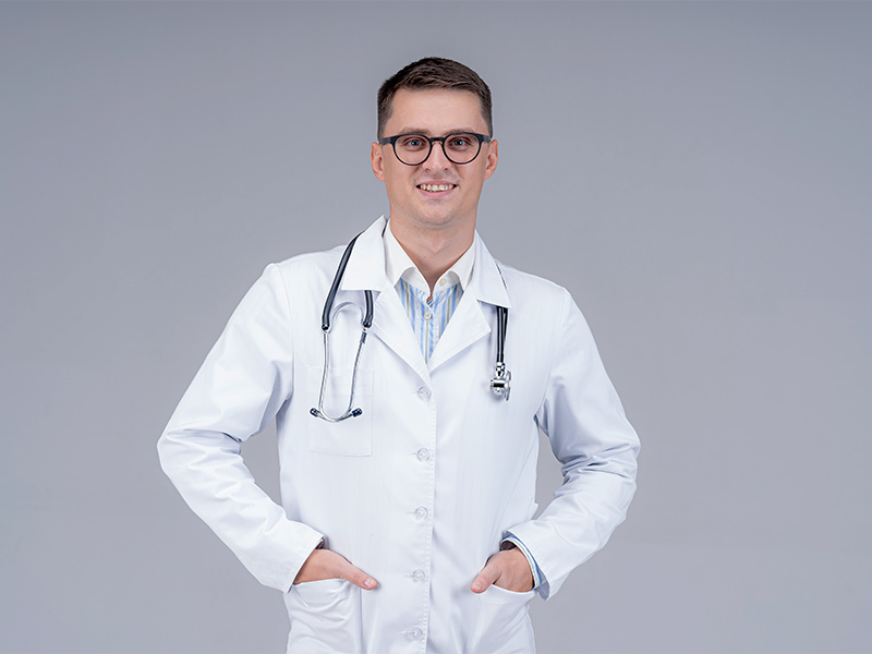 Médico que trata a ginecomastia sorrindo, com a mão no bolso do jaleco