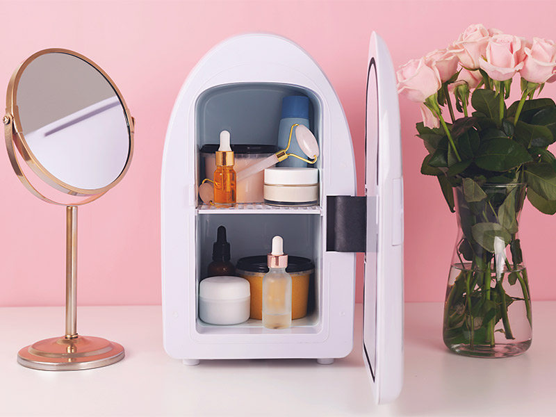 Imagem com diversos produtos de skincare dentro de uma mini geladeira para cosméticos