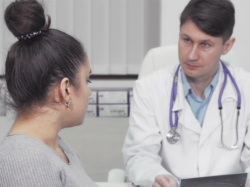 Imagem de uma paciente conversando com seu médico sobre como acabar com a pele flácida no rosto e pescoço
