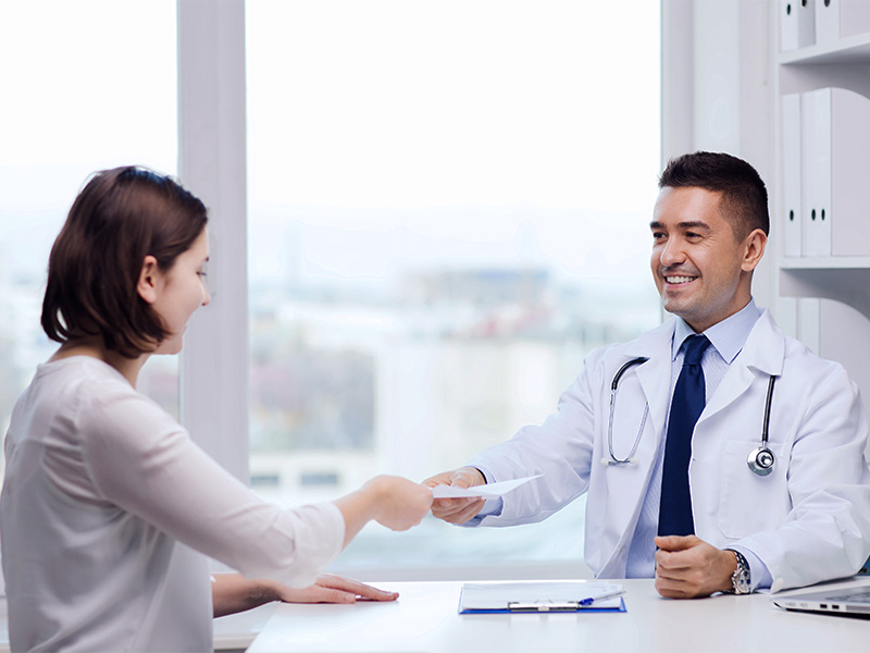 Mulher recebendo um papel com a avaliação do médico sobre o tratamento para diminuir os seios 