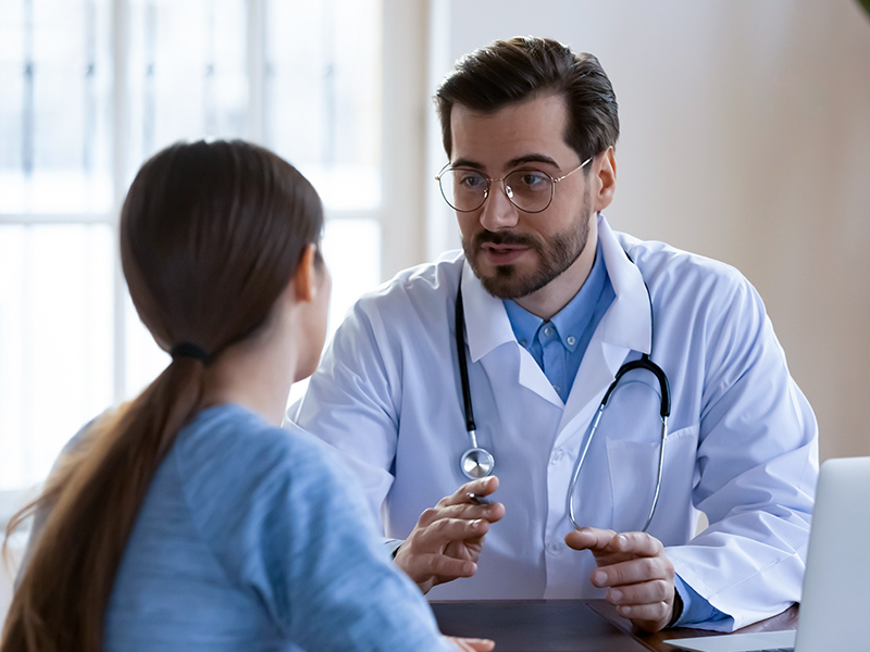 Mulher conversando com o médico se a melhor forma de ter uma cicatriz bonita é a pomada cicatrizante