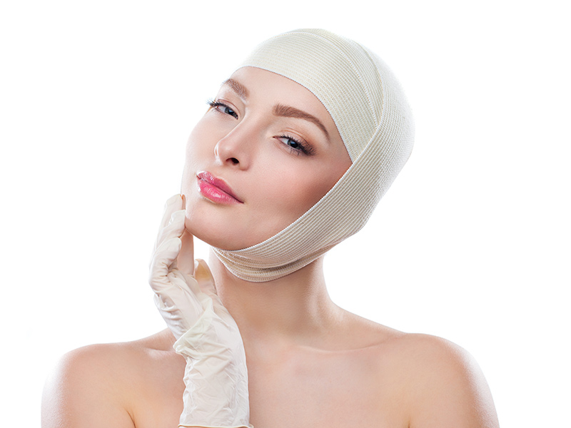 Imagem de uma mulher usando capacete cirúrgico, que é um tipo de curativo usado no pós-operatório de otoplastia