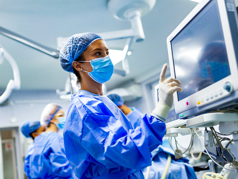Anestesista verificando os sinais vitais de paciente em centro cirúrgico