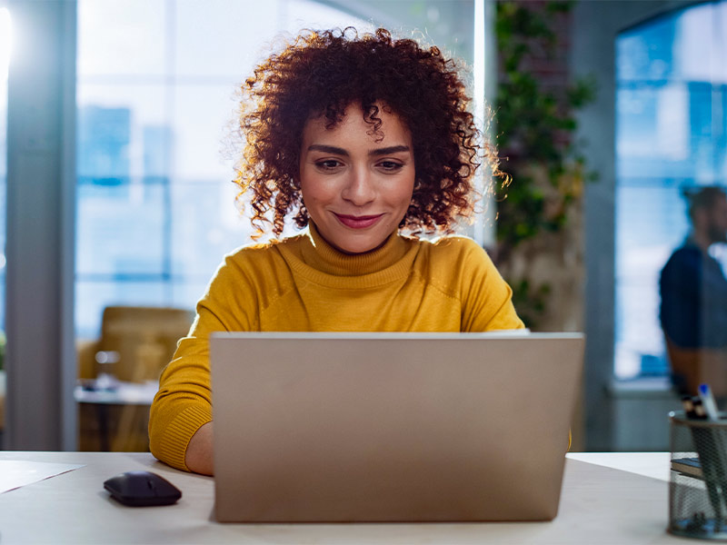 Mulher pesquisando no notebook os principais fatores para ter uma cirurgia plástica segura