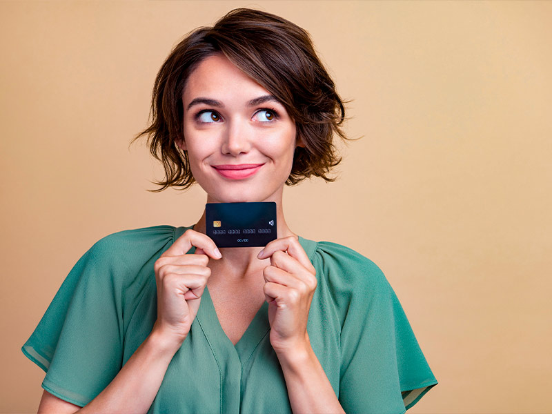 Mulher feliz segurando um cartão de crédito para fazer a abdominoplastia