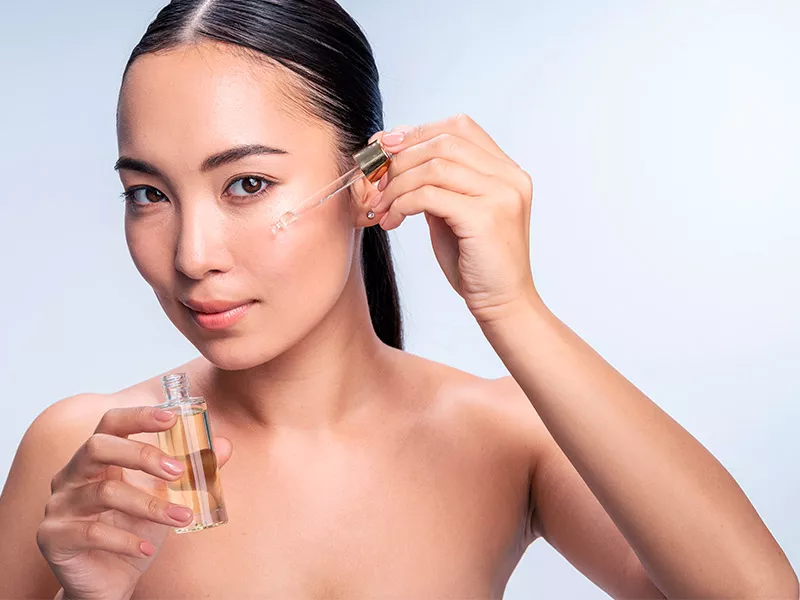 Os séruns fazem bem para a pele? Foto de uma mulher aplicando o sérum de ácido hialurônico no rosto