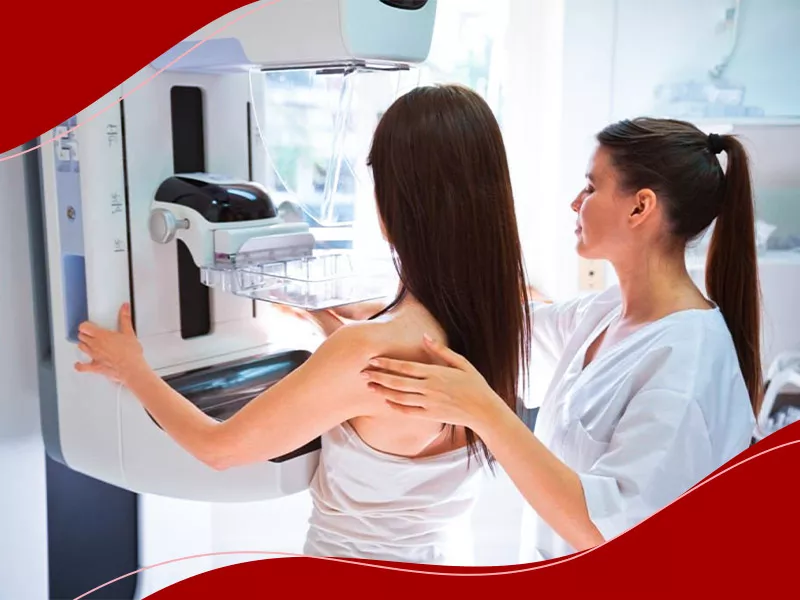 Por que os exames pré-operatórios são essenciais? Enfermeira guiando mulher para fazer um dos exames para colocar silicone, a mamografia
